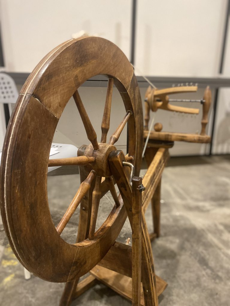 Image shows a traditional wooden spinning wheel. 